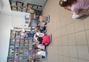 dzieci siedzą w bibliotece