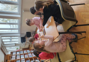 Dzieci siedzą przy stole.