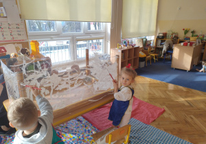 Dziewczynka i chłopiec malują pędzelkami