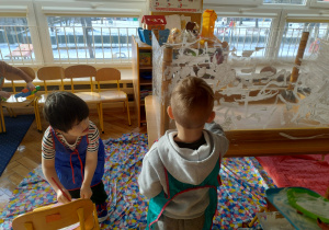 Chłopcy malują folię na biało