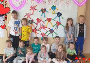 Grupa pozuje na tle wykonanych przez siebie prac