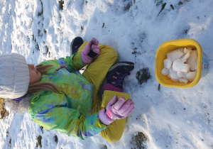 dziewczynka siedzi na śniegu
