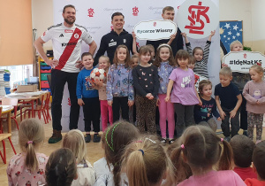 Dzieci ze sportowcami pozują do wspólnego zdjęcia