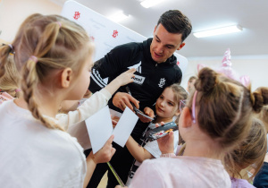 Sportowiec rozdaje autografy