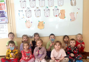 Grupa prezentuje wykonane koty na tle napisu