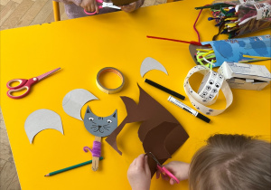 Dzieci wycinają sylwetki kotów