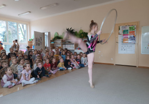 Dziewczynka prezentuje układ ze srebrnym hula-hop