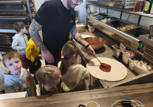 Kucharz smaruje ciasto sosem