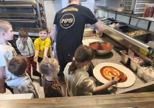 Dziewczynka smaruje ciasto sosem