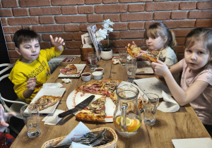 Grupa je pizzę przy stoliku