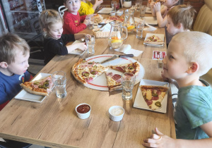 Grupa dzieci je pizzę