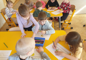 Dzieci wykonują opaski na dzień dinozaura