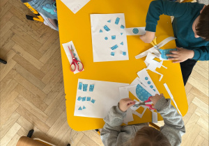 Dzieci wycinają elementy dinozaura