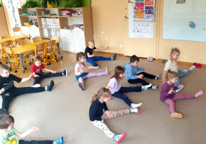 Grupa wykonuje ćwiczenia w rozkroku