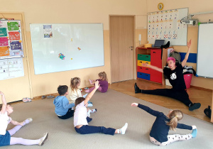 Grupa ćwiczy w siadzie wymachy rąk