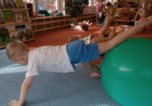 Chłopiec ćwiczy na piłce