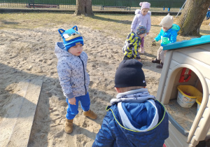 Dzieci stoją przy domku