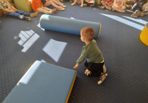 Chłopiec siedzi obok materaca