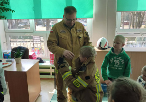 Chłopiec przymierza strój strażaka