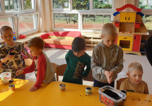 Dzieci nakładają ziemię do doniczek