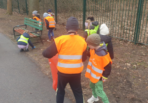 Chłopiec wrzuca śmieci do worka