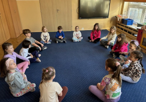 Dzieci siedzą w kole