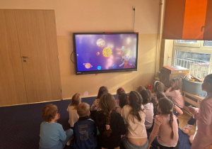 Dzieci oglądają film edukacyjny o Układzie Słonecznym