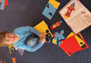 Chłopiec siedzi na dywanie