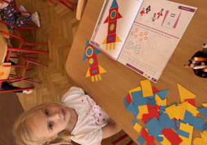 Dziewczynka ułożyła z figur geometrycznych rakietę