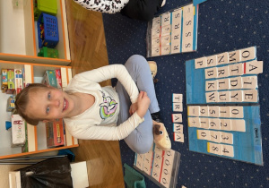 Dziewczynka siedzi na dywanie