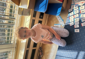 Dziewczynka prezentuje ułożone przez siebie wyrazy