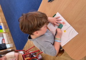 Chłopiec wykonuje pracę plastyczną na konkurs