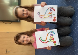 Dziewczynki prezentują swoje prace plastyczne