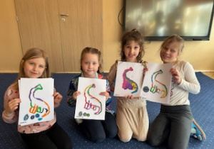 Dzieci siedzą na dywanie