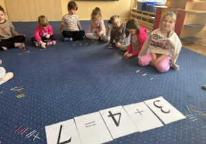 Dzieci siedzą na dywanie