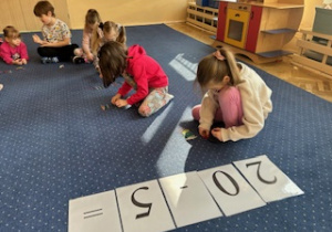 Dzieci siedzą na dywanie