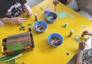 Dzieci wykonują żabki z papieru kolorowego