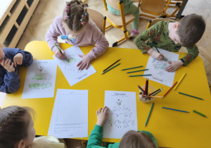 Dzieci wykonują zadanie w kartach pracy