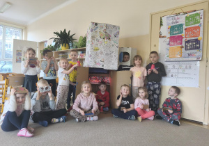 Grupa siedzi przed wykonaną przez siebie rakietą