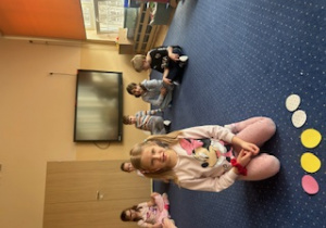 Dziewczynka układa papierowe jajka na dywanie