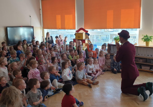 Magik na kolanach przed dziećmi