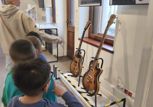 Grupa ogląda ekspozycję z gitarami