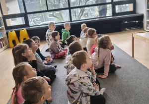 Dzieci siedzą na dywanie