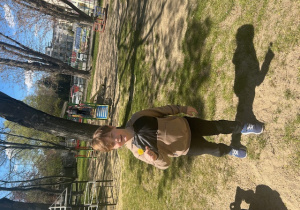 Chłopiec trzyma w dłoni mniszka lekarskiego