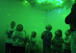 Grupa patrzy na chmury w odcieniach zielonego