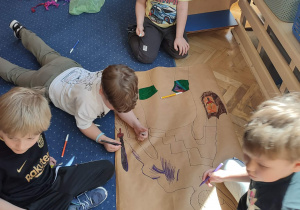 Chłopcy siedzą na dywanie