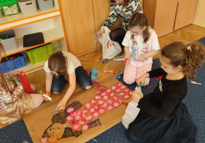 Dziewczynka nakleja materiał na papier