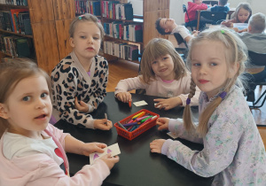 Dzieci siedzą przy stolikach