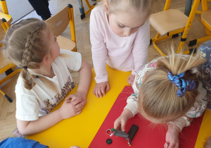 Dziewczynka zbiera szpilki przy pomocy magnesu
