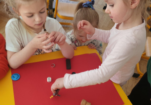 Dziewczynki sprawdzają jakiego rodzaju materiał przyciągają magnesy